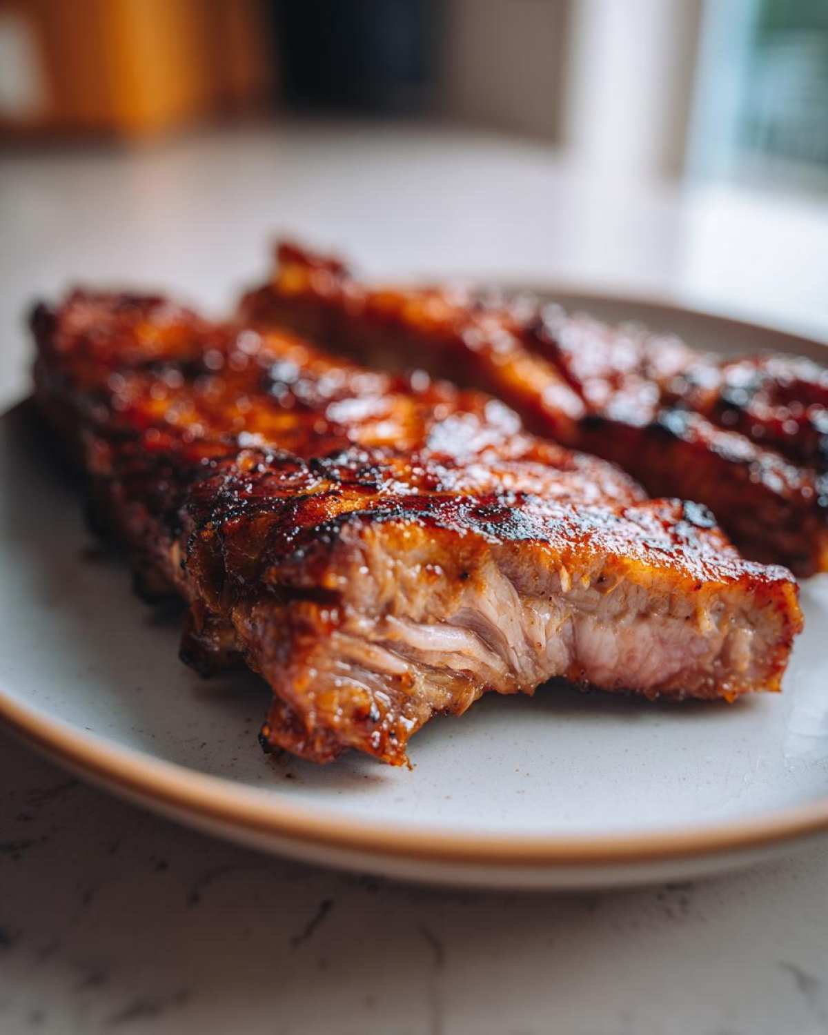 Zbliżenie na kawałek soczystej karkówki z grilla z widoczną marynatą, leżącej na talerzu. marynata do karkówki na grilla.