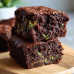 Zdjęcie z bliska brownie z cukinii, ukazujące wilgotną konsystencję i kawałki cukinii.