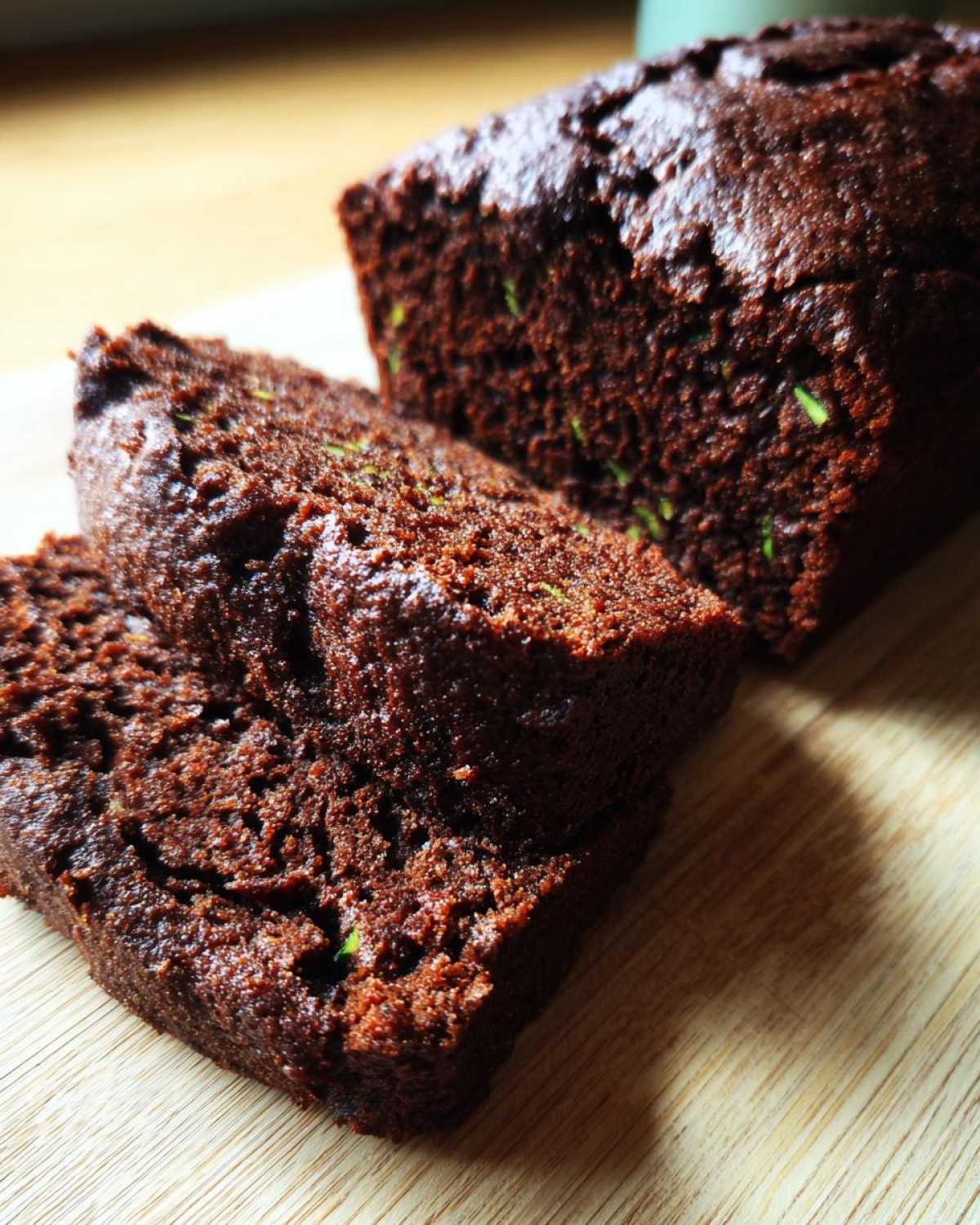 Kawałki brownie z cukinii na drewnianej desce. Pyszny i wilgotny deser.