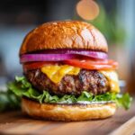 Soczysty domowy burger wołowy z serem, pomidorem, czerwoną cebulą i sałatą. Idealny domowy burger wołowy.