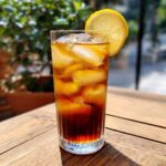 Szklanka espresso tonic z lodem i plasterkiem cytryny. Idealny napój na lato.