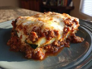 Kawałek lasagne z cukinii z sosem mięsnym i serem, podany na talerzu. Pyszna Lasagne z cukinii.