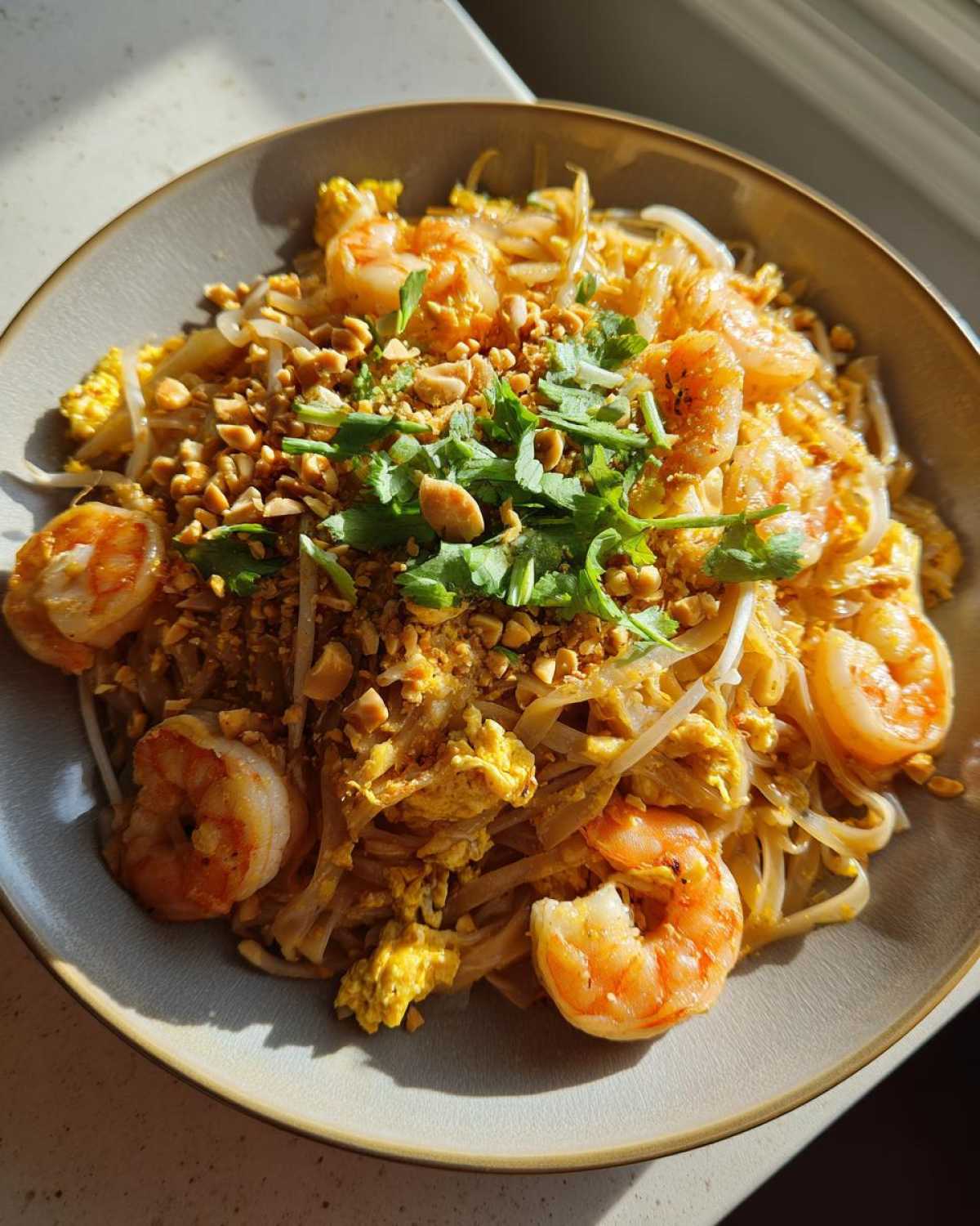 Zdjęcie Pad Thai z krewetkami, orzechami i kolendrą w misce. Idealny na szybki obiad.