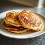 Zdjęcie przedstawia stos pysznych placuszków bananowych fit na białym talerzu.