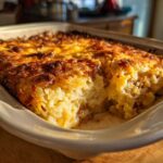 Zdjęcie zapiekanki ziemniaczanej z boczkiem w naczyniu do pieczenia, ukazujące jej wnętrze.