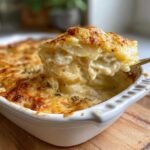 Kremowa zapiekanka ziemniaczana z serem, z widocznym złotym, przypieczonym serem i warstwami ziemniaków.