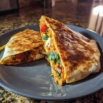 Przekrój domowego Crunchwrap Supreme z widocznymi warstwami mięsa, sera, pomidorów i ziół.