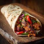 Domowy kebab z kurczaka w tortilli z warzywami: papryką, cebulą i ziołami.