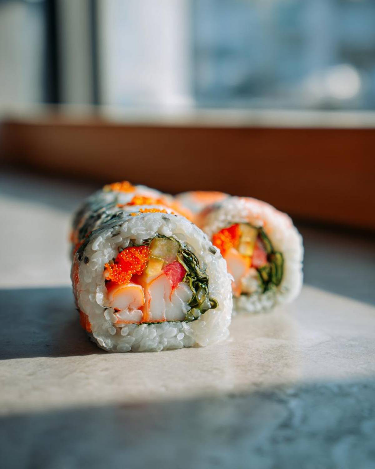 Zbliżenie na sushi maki z krewetkami, ogórkiem, łososiem i ikrą latającej ryby.