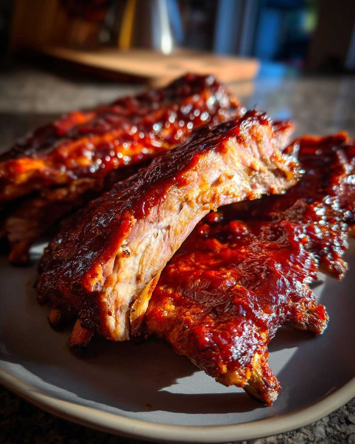 Zbliżenie na soczyste żeberka barbecue pokryte błyszczącym, ciemnym sosem.
