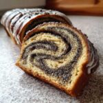 Kawałek makowca tradycyjnego (zawijanego) z widocznym spiralnym nadzieniem makowym i lukrem.
