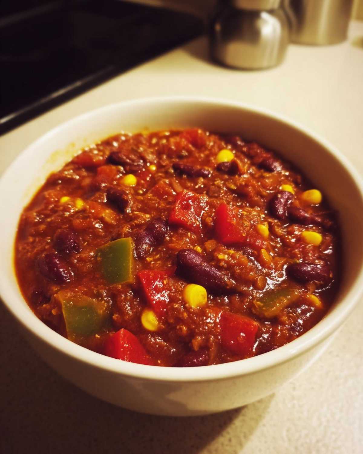 Zbliżenie na miseczkę gęstego, aromatycznego chili sin carne z fasolą, kukurydzą i papryką.