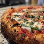 Zbliżenie na krawędź i wierzch idealnie wypieczonej pizzy margherita z puszystym, przypalonym brzegiem i świeżą bazylią.