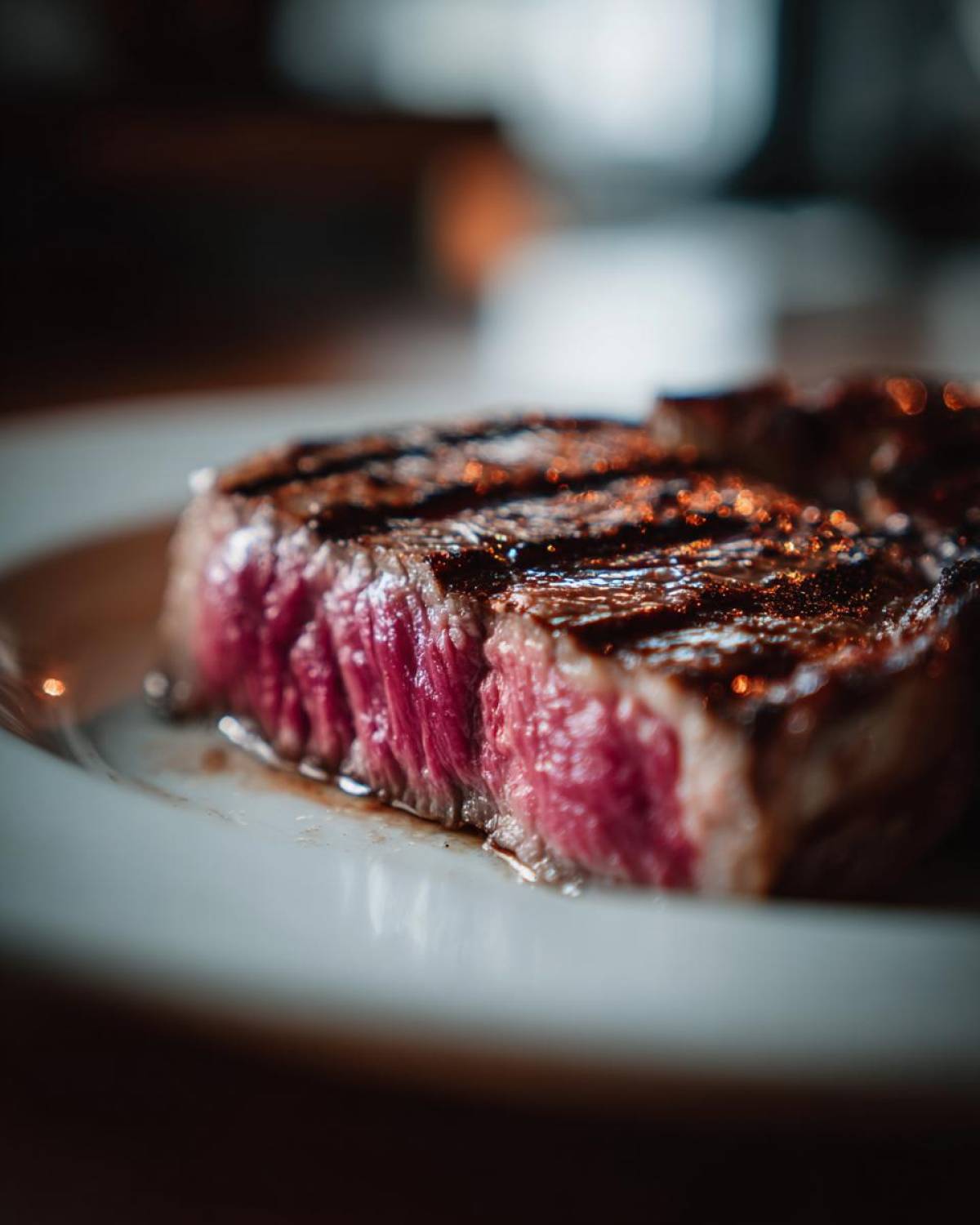 Zbliżenie na przekrój idealnego steka wołowego, wysmażonego na medium-rare, z widocznymi śladami grilla.