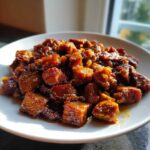 Kawałki ciemnego, duszonego mięsa wieprzowego w gęstym sosie, czyli Gulasz wieprzowy z szynki.