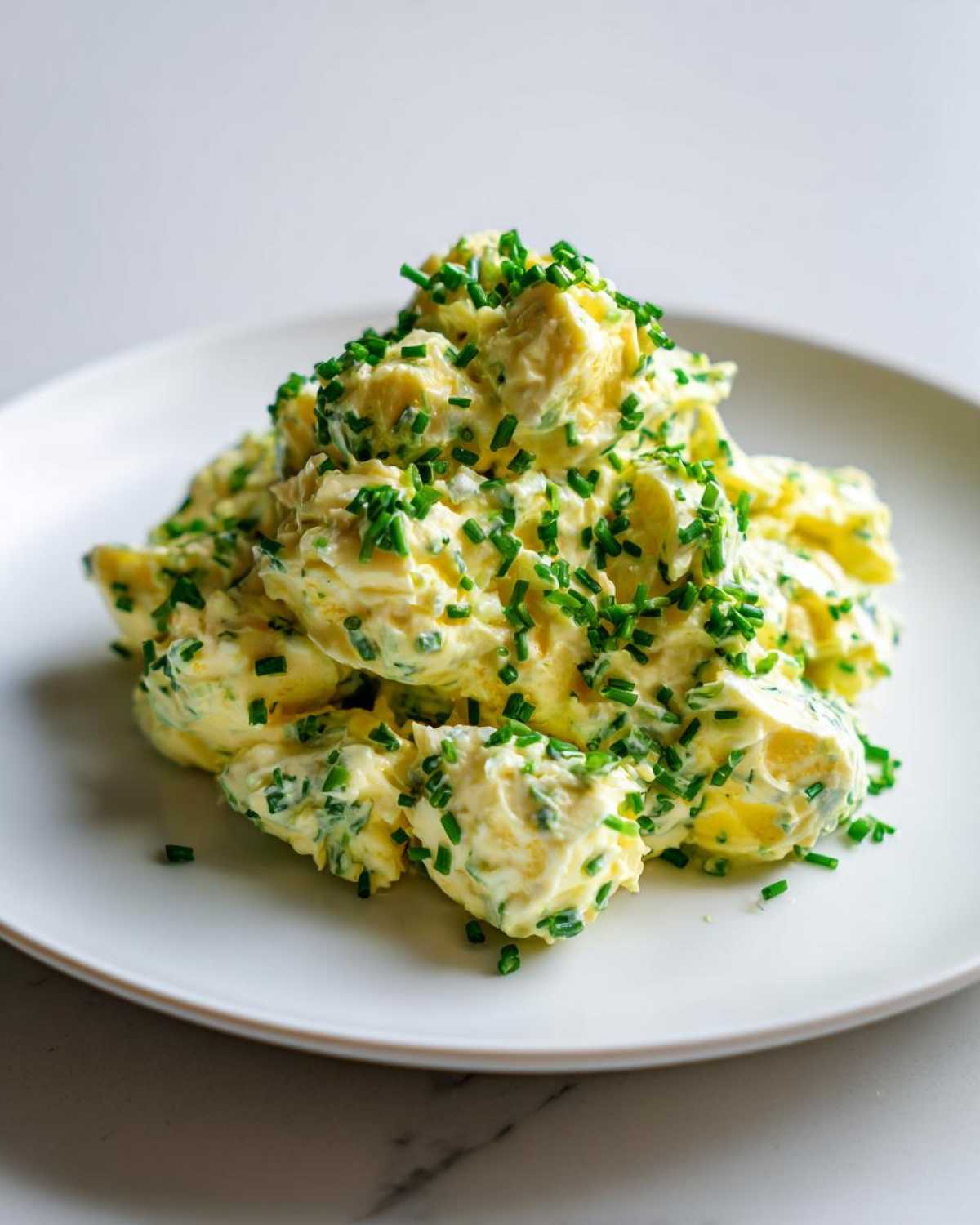 Zbliżenie na porcję Klasyczna pasta jajeczna ze szczypiorkiem, obficie posypana świeżym szczypiorkiem.