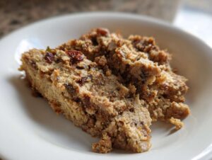 Zbliżenie na porcję dania Pasta z resztek pieczonego mięsa, wyglądającego jak zapiekanka lub pasztet, na białym talerzu.