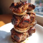 Zbliżenie na grillowany Kebab z karkówki z grilla nabity na szpikulec z kawałkami cebuli.