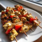 Grillowane Souvlaki z kurczaka z papryką i cebulą, obficie posypane ziołami.
