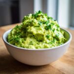 Gęste, świeże Guacamole do mięs z grilla posypane posiekaną kolendrą w jasnej misce.